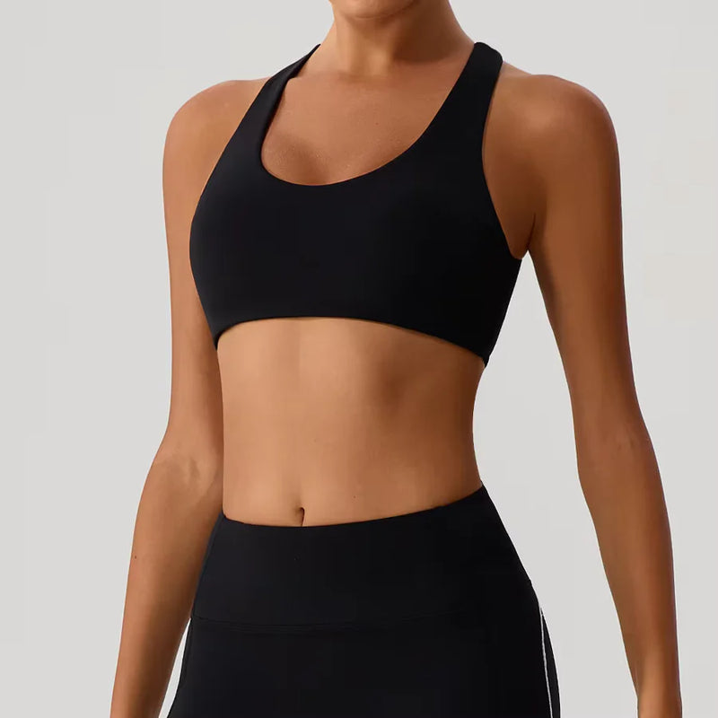 Person wearing a black sports bra and leggings on a plain background