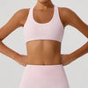 Person wearing a light pink sports bra and leggings on a plain background